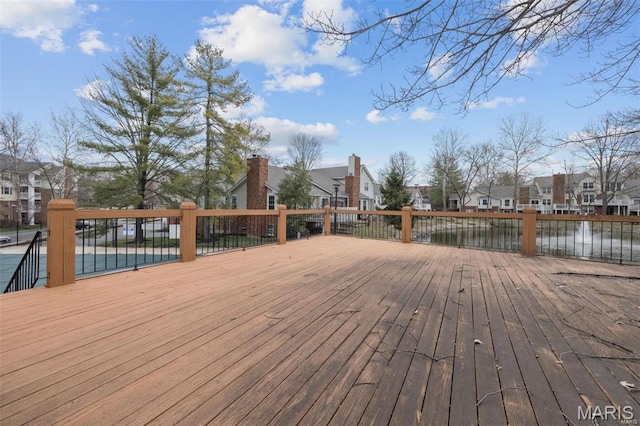 wooden deck with a residential view and a water view