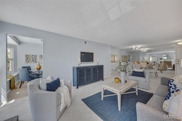 carpeted living room featuring plenty of natural light and a textured ceiling