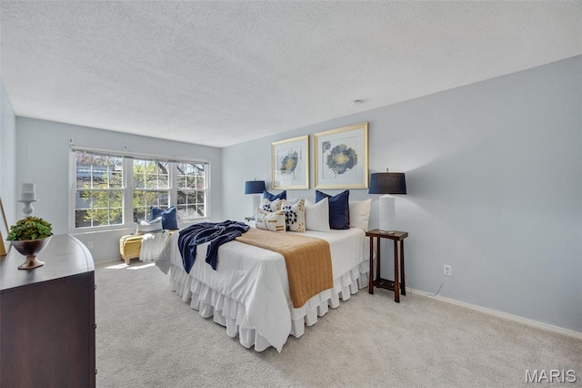 bedroom featuring a textured ceiling, carpet, and baseboards