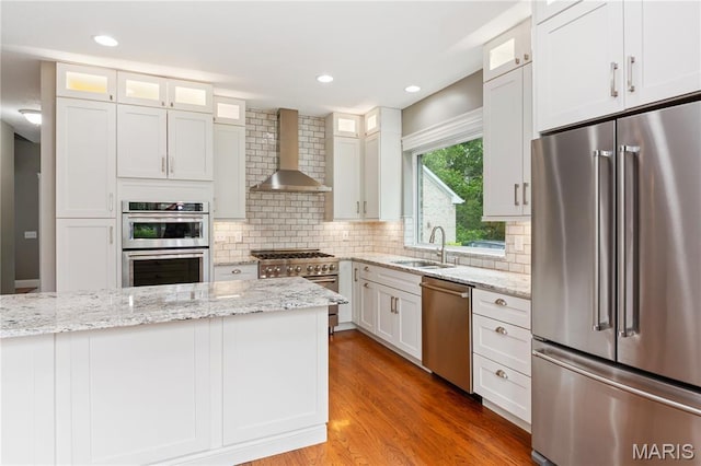 809 Star Ridge Ct, Defiance, MO 63341 - kitchen featuring high end appliances, wall chimney range hood, decorative backsplash, light wood finished floors, and light stone counters