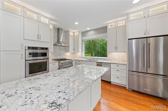 809 Star Ridge Ct, Defiance, MO 63341 - kitchen featuring stainless steel appliances, wall chimney range hood, recessed lighting, decorative backsplash, and light wood-style flooring