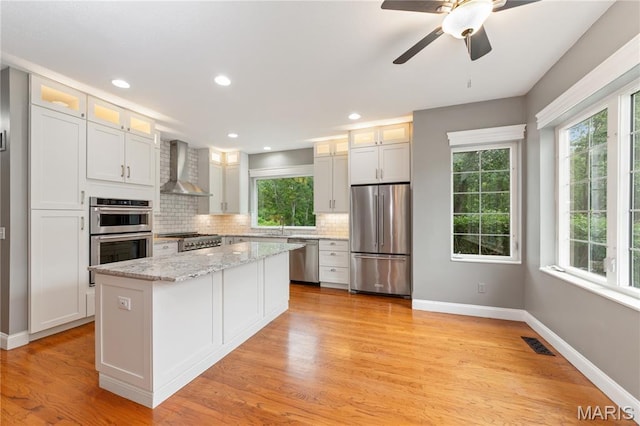 809 Star Ridge Ct, Defiance, MO 63341 - kitchen featuring appliances with stainless steel finishes, wall chimney range hood, healthy amount of natural light, backsplash, and recessed lighting