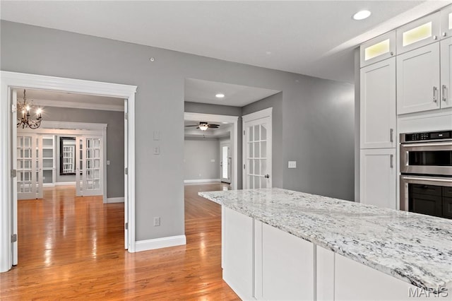 809 Star Ridge Ct, Defiance, MO 63341 - kitchen with french doors, light wood-style flooring, recessed lighting, glass insert cabinets, and light stone countertops