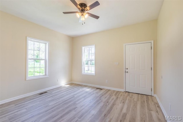 spare room featuring light wood-style floors, ceiling fan, and baseboards