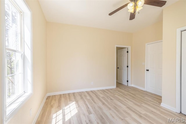 unfurnished room featuring light wood-style floors, ceiling fan, and baseboards