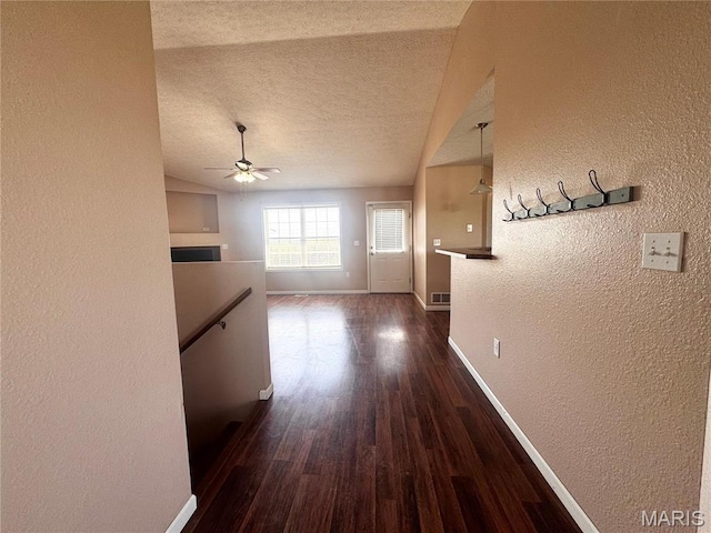 18410 Charity Dr, Dixon, MO 65459 - hallway featuring a textured wall, baseboards, dark wood-type flooring, a textured ceiling, and an upstairs landing
