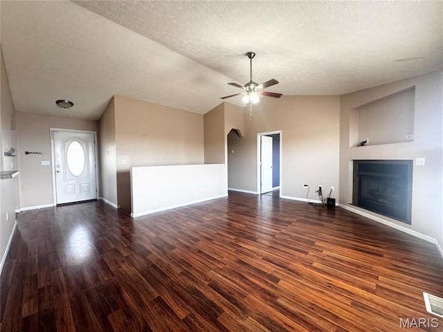 18410 Charity Dr, Dixon, MO 65459 - unfurnished living room featuring a fireplace, lofted ceiling, wood finished floors, a ceiling fan, and a textured ceiling
