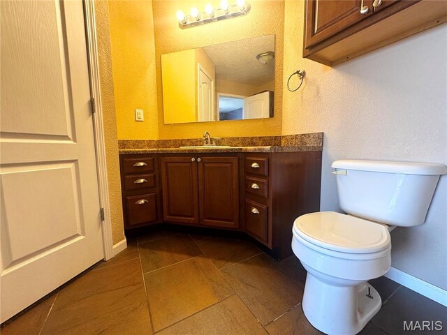 18410 Charity Dr, Dixon, MO 65459 - bathroom featuring toilet, vanity, baseboards, tile patterned flooring, and a textured wall