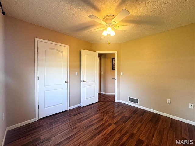 18410 Charity Dr, Dixon, MO 65459 - unfurnished bedroom with dark wood-style floors, baseboards, a textured ceiling, and a ceiling fan