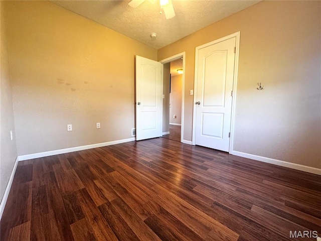 18410 Charity Dr, Dixon, MO 65459 - unfurnished bedroom with baseboards, dark wood-style floors, a ceiling fan, and a textured ceiling