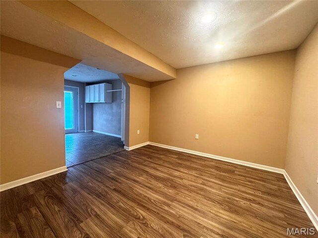 18410 Charity Dr, Dixon, MO 65459 - bonus room with dark wood-style flooring, baseboards, and a textured ceiling