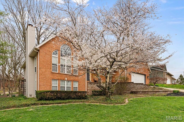 1029 Stonybrook Dr, Ofallon, IL 62269 - view of front of house featuring a chimney, brick siding, a front lawn, and an attached garage