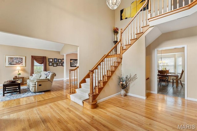 1029 Stonybrook Dr, Ofallon, IL 62269 - stairs with a high ceiling, wood finished floors, a chandelier, and baseboards