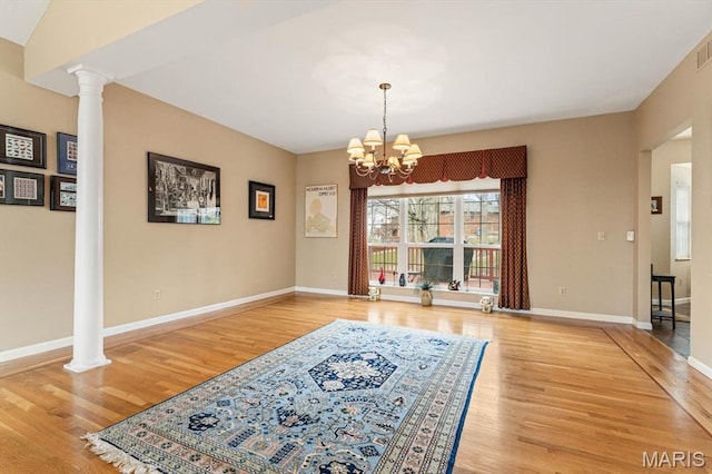 1029 Stonybrook Dr, Ofallon, IL 62269 - unfurnished dining area with ornate columns, wood finished floors, and a chandelier