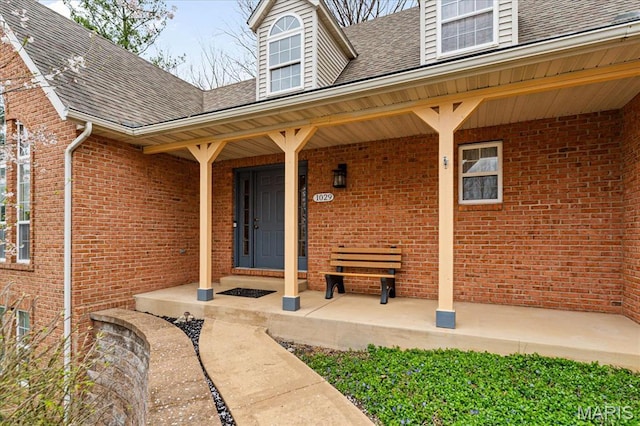 1029 Stonybrook Dr, Ofallon, IL 62269 - property entrance with roof with shingles, brick siding, and covered porch