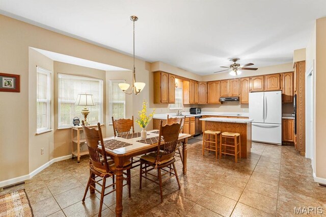 1029 Stonybrook Dr, Ofallon, IL 62269 - dining area featuring baseboards, light tile patterned floors, a ceiling fan, and a chandelier