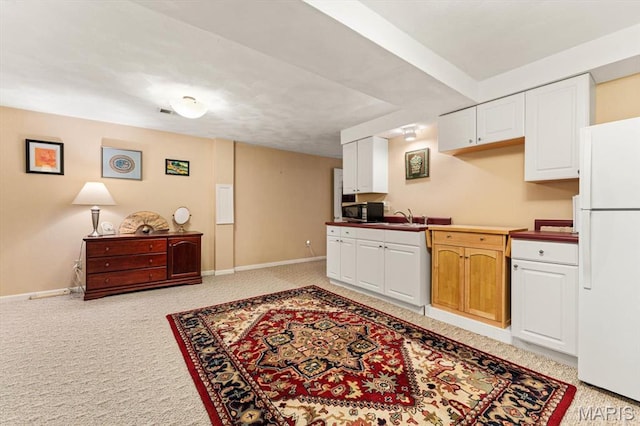 1029 Stonybrook Dr, Ofallon, IL 62269 - kitchen with freestanding refrigerator, stainless steel microwave, a sink, light colored carpet, and baseboards