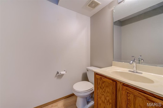 7 Park City Ct, Ofallon, MO 63368 - half bathroom featuring toilet, vanity, wood finished floors, and baseboards