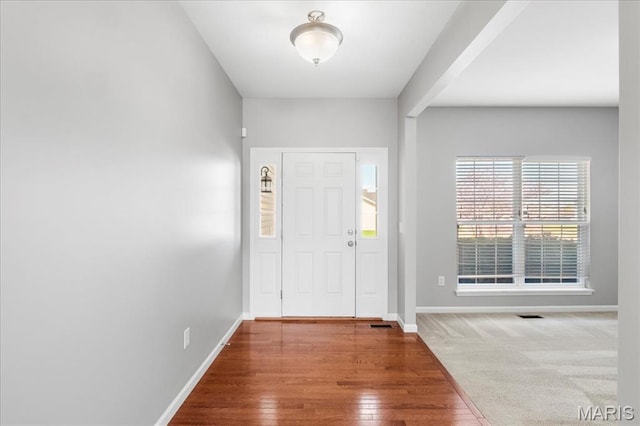 entrance foyer with baseboards and wood finished floors