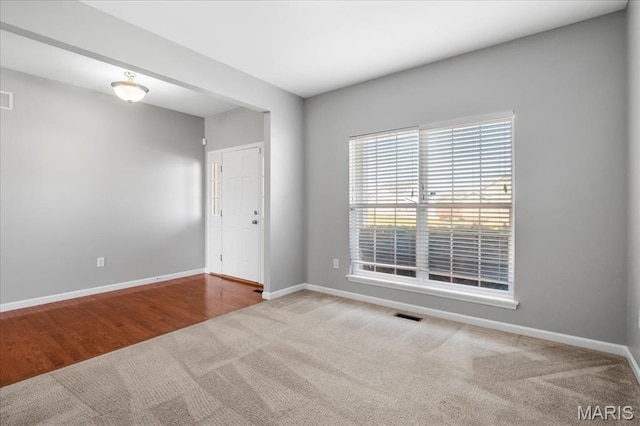 carpeted spare room with baseboards