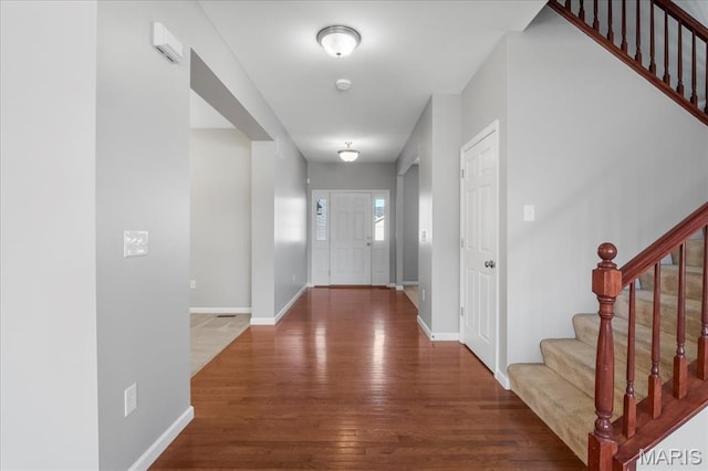 entryway with wood finished floors, stairs, and baseboards