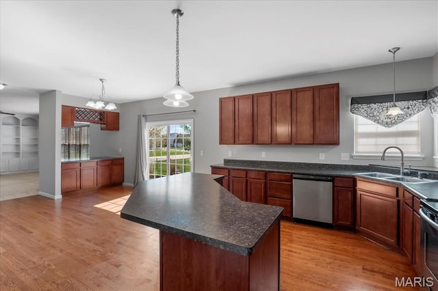 kitchen with stainless steel dishwasher, a sink, dark countertops, and light wood-type flooring