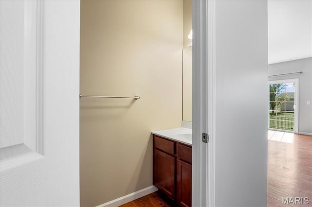 bathroom featuring wood finished floors, vanity, and baseboards