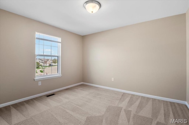 spare room with light colored carpet and baseboards