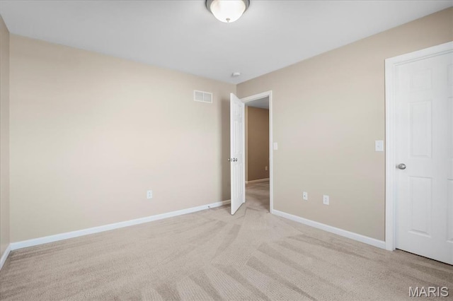 unfurnished room with baseboards and light colored carpet