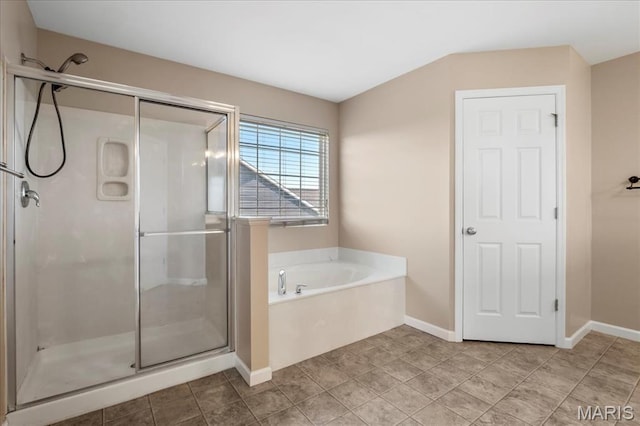 bathroom featuring a shower stall, a garden tub, and baseboards