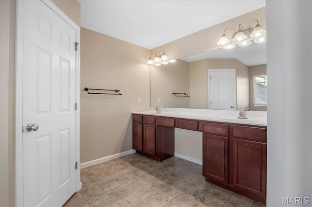 bathroom with baseboards and double vanity