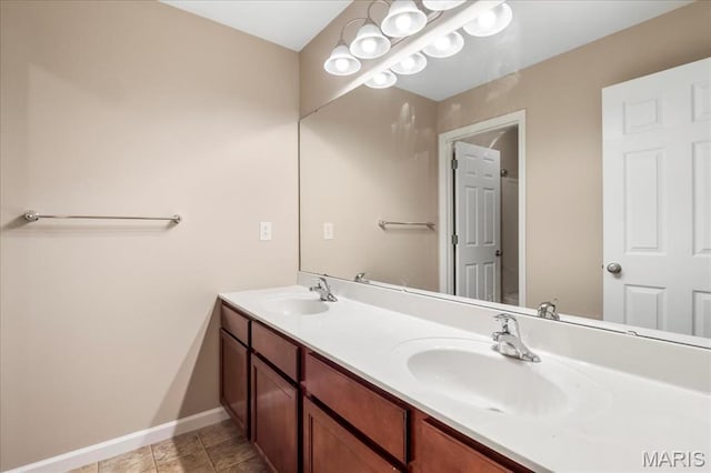 bathroom featuring double vanity, baseboards, and tile patterned floors