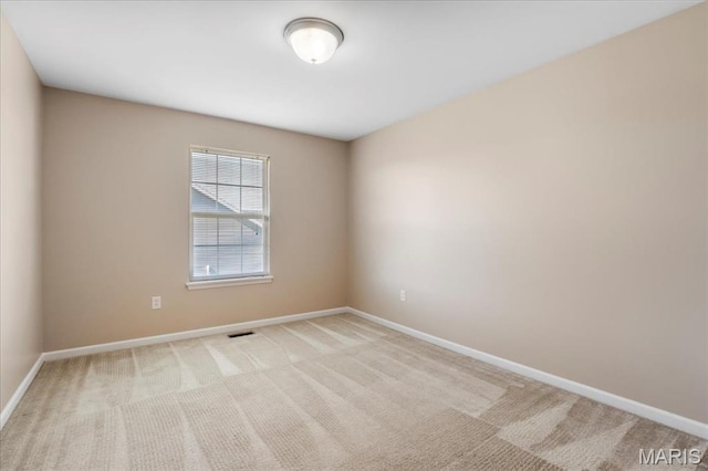 carpeted empty room featuring baseboards