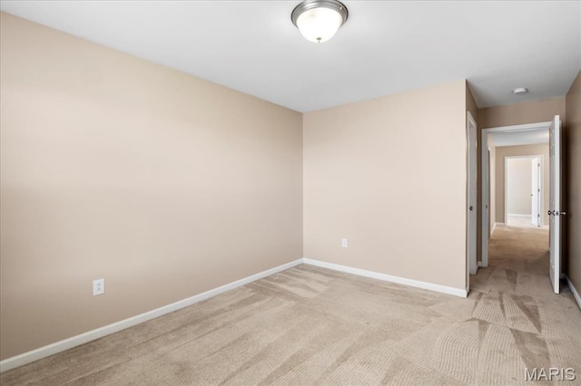 empty room with light colored carpet and baseboards