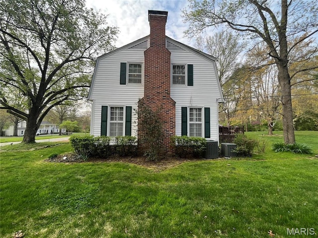 1843 Manor Hill Rd, Saint Louis, MO 63131 - view of side of home with a gambrel roof, a lawn, a chimney, and cooling unit