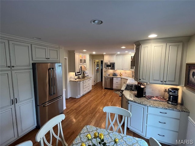 1843 Manor Hill Rd, Saint Louis, MO 63131 - kitchen with stainless steel appliances, decorative backsplash, wood finished floors, recessed lighting, and a sink