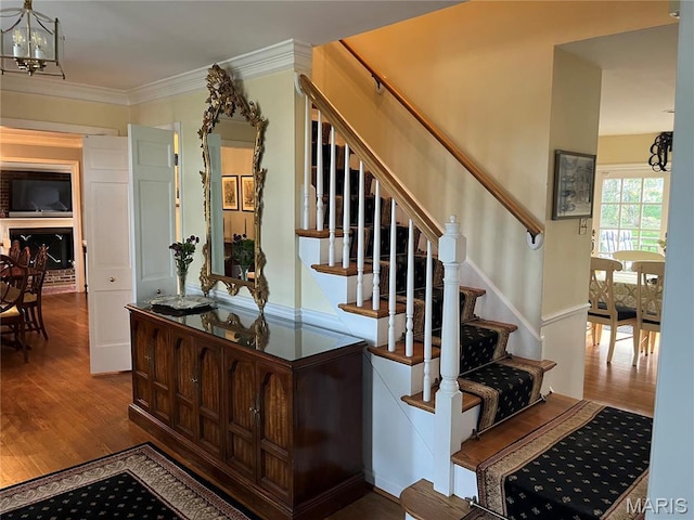 1843 Manor Hill Rd, Saint Louis, MO 63131 - stairs with wood finished floors, a chandelier, and ornamental molding