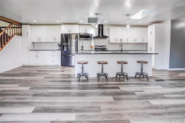 26152 Beltrees Rd, Dow, IL 62022 - kitchen with stainless steel appliances, wall chimney range hood, dark countertops, a skylight, and white cabinets