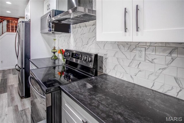 26152 Beltrees Rd, Dow, IL 62022 - kitchen featuring stainless steel appliances, wall chimney exhaust hood, dark countertops, white cabinetry, and backsplash