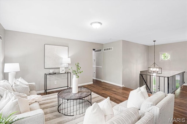 2145 Glenoro Dr, Florissant, MO 63033 - living room featuring a chandelier, baseboards, and wood finished floors