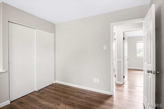 2145 Glenoro Dr, Florissant, MO 63033 - unfurnished bedroom featuring wood finished floors, a closet, and baseboards