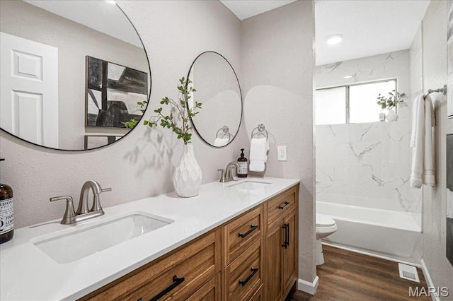 2145 Glenoro Dr, Florissant, MO 63033 - bathroom featuring toilet, wood finished floors, double vanity, and bathing tub / shower combination
