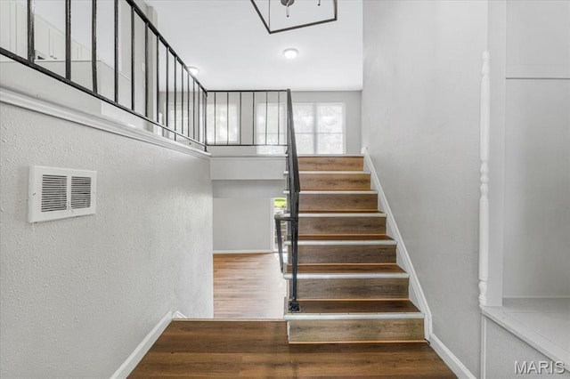 2145 Glenoro Dr, Florissant, MO 63033 - stairway featuring baseboards, wood finished floors, and a textured wall