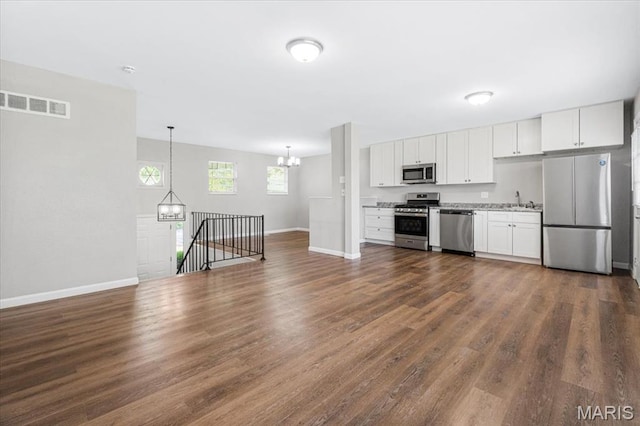 2145 Glenoro Dr, Florissant, MO 63033 - kitchen with stainless steel appliances, baseboards, dark wood-style floors, and white cabinets
