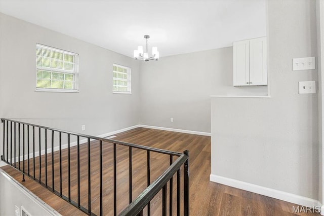 2145 Glenoro Dr, Florissant, MO 63033 - spare room with wood finished floors, a chandelier, and baseboards