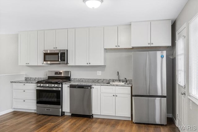 2145 Glenoro Dr, Florissant, MO 63033 - kitchen featuring appliances with stainless steel finishes, a sink, healthy amount of natural light, and dark wood-type flooring