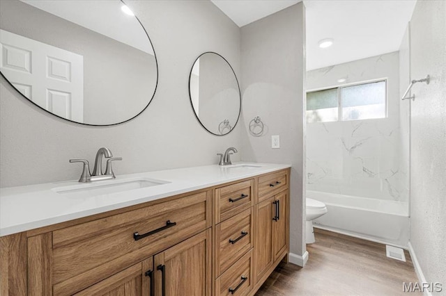 2145 Glenoro Dr, Florissant, MO 63033 - bathroom with toilet, double vanity, wood finished floors,  shower combination, and baseboards