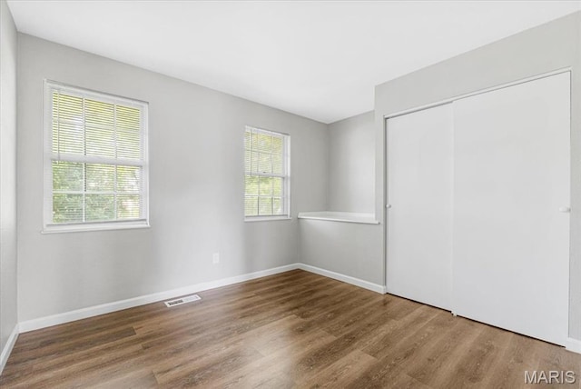 2145 Glenoro Dr, Florissant, MO 63033 - unfurnished bedroom featuring wood finished floors, a closet, and baseboards