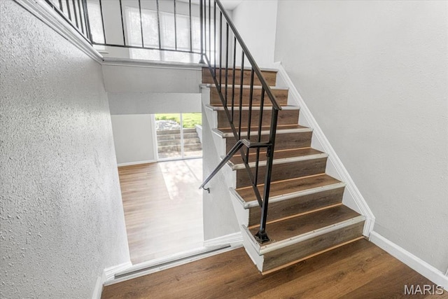 2145 Glenoro Dr, Florissant, MO 63033 - stairway featuring a textured wall, wood finished floors, and baseboards