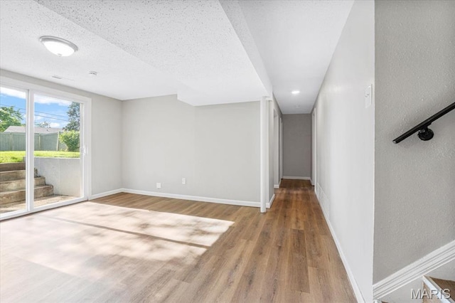 2145 Glenoro Dr, Florissant, MO 63033 - spare room with wood finished floors, baseboards, stairs, and a textured wall